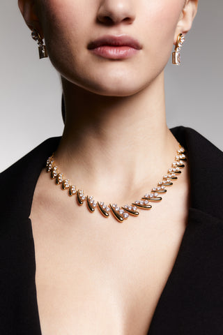 CLOSE UP OF MODEL WEARING PHENOM LARGE COLLAR NECKLACE. SHE HAS ON A BLACK V-NECK COLARED SHIRT ON. IT IS A CLOSE UP OF HER NOSE DOWN TO SHOW DETAILS OF THE PAVE CZ ON THE NECKLACE. 